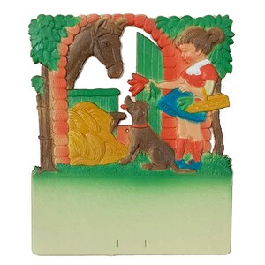 May include: A vintage, colorful, paper calendar featuring a girl with a basket of flowers, a brown horse, and a brown dog. The calendar has a green, yellow, and red background.