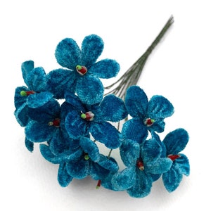 May include: A bouquet of ten teal blue velvet flowers with green stems and red centers. The flowers are arranged in a cluster and are ready to be used for crafting.