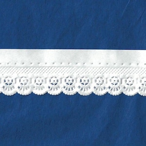May include: White lace trim with a scalloped edge and a decorative floral pattern. The trim has a solid white band above the lace, and is set against a blue background. This trim is suitable for sewing and craft projects.