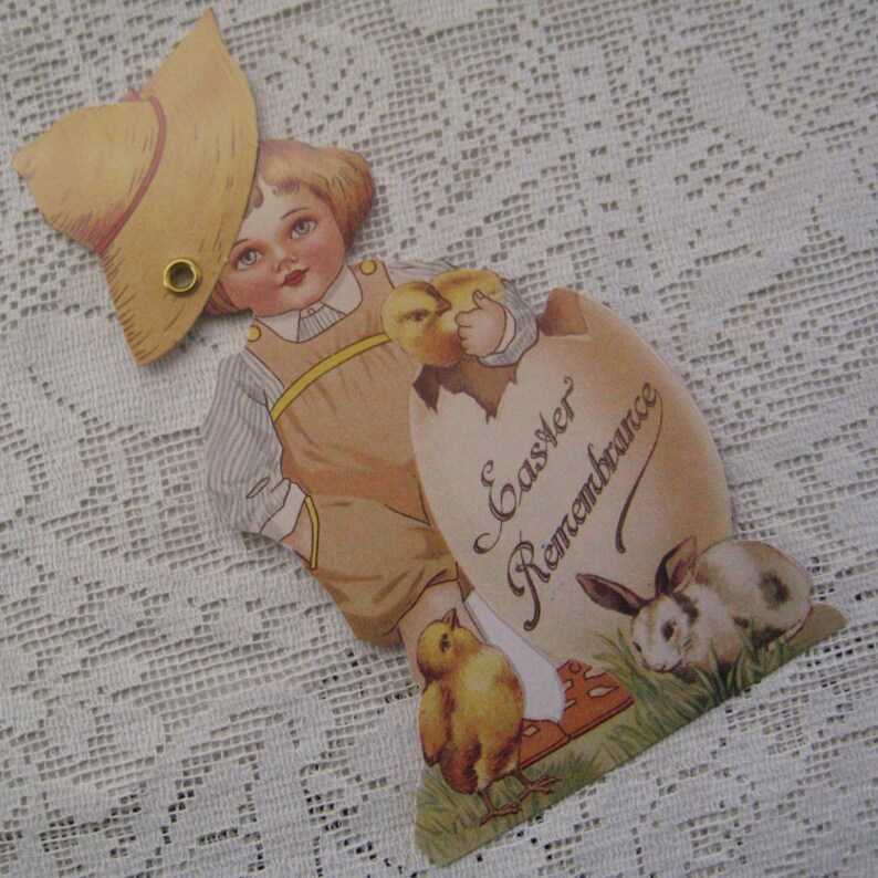 May include: Vintage Easter card featuring a child wearing a straw hat and holding a chick. The card has a heart-shaped design with the text "Easter Remembrance" written in cursive.