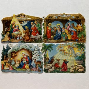 May include: Four vintage Christmas card cutouts depicting Nativity scenes. Each card features detailed illustrations of the birth of Jesus, the visit of the wise men, and other biblical scenes. The cards are in various colors and feature text.
