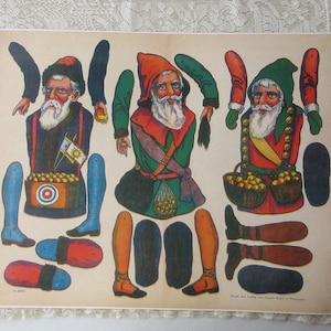 May include: Vintage paper dolls featuring three bearded men with hats and various outfits. Each figure has separate arms and legs. One figure has a basket of apples, another holds an apple, and the third has a bag of apples.