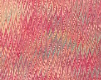 May include: Abstract marbled paper with a chevron pattern in shades of pink, red, orange, and green.