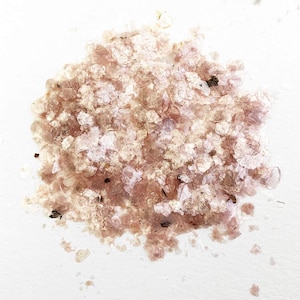 May include: A pile of iridescent pink and white mica flakes, a type of mineral used in crafts and cosmetics.