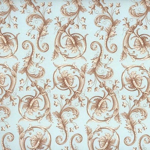 May include: A repeating pattern of ornate, swirling floral and leaf designs in shades of brown and beige against a light blue background. The detailed, symmetrical arrangement creates a classic, decorative wallpaper or fabric design.