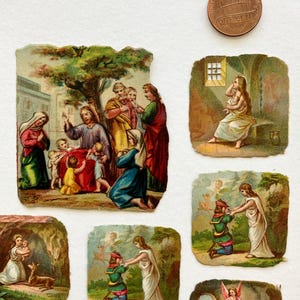 May include: A collection of vintage religious paper ephemera featuring colorful illustrations of biblical scenes. The images depict figures in various settings, with detailed artwork and a faded, aged appearance. A US one-cent coin is included for size reference.