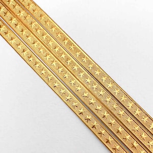 May include: Four gold-colored metal trim strips with a repeating star pattern.