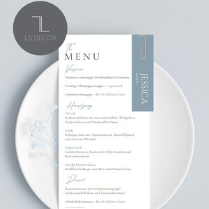 Puede incluir: Una tarjeta de menú de boda con un diseño minimalista, que enumera platos en alemán. La tarjeta blanca tiene un clip azul y el nombre "Jessica". El menú está en un plato blanco.