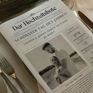 May include: A black and white newspaper-style announcement for a wedding. The headline reads "Schonster Tag des Jahres!" which translates to "Most Beautiful Day of the Year!" The announcement features a photo of the couple, Liliana and Jonas, and includes the date of the wedding, 24 August 2024.