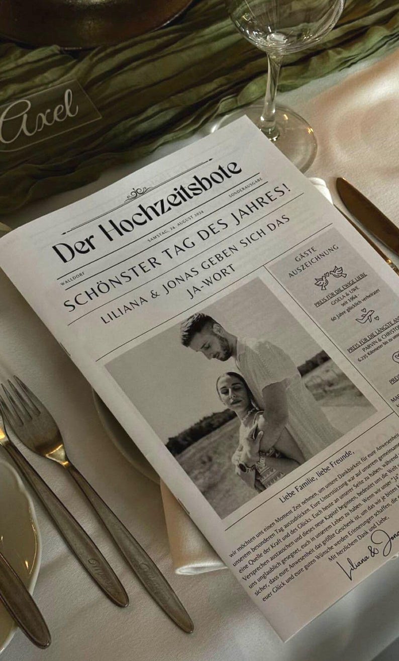 May include: A black and white newspaper-style announcement for a wedding. The headline reads "Schonster Tag des Jahres!" which translates to "Most Beautiful Day of the Year!" The announcement features a photo of the couple, Liliana and Jonas, and includes the date of the wedding, 24 August 2024.