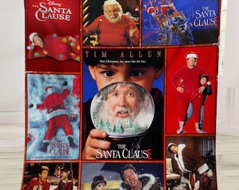 May include: A red fleece blanket featuring multiple images from the movie "The Santa Clause." The blanket showcases various scenes with Tim Allen, including the movie title and the phrase "This Christmas, the snow hits the fan."