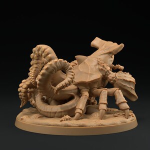 May include: A brown, detailed miniature of a creature with a crab-like body and an octopus-like head. The creature is posed on a round base with a sandy texture.