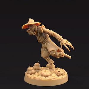 May include: A tan-colored figurine of a scarecrow with a wide-brimmed hat, tattered clothing, and long, claw-like fingers. The scarecrow is posed with a slight lean, standing on a base with pumpkins. A carved jack-o'-lantern is also present.