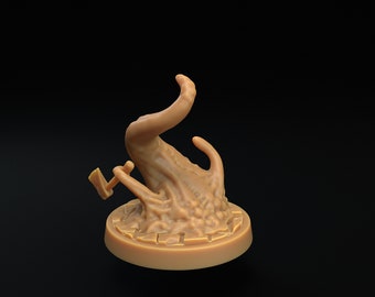 Puede incluir: Una figurita miniatura de color marrón con forma de mano y una pequeña hacha que sobresale. La figurita está de pie sobre una base redonda y texturizada.