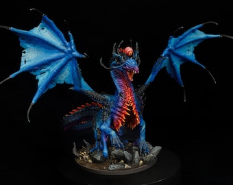 May include: A blue and red dragon figurine with a single red eye on its head. The dragon has large, blue wings and is posed in a standing position with its mouth open.