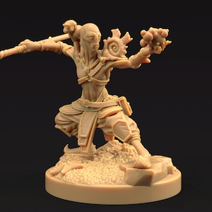 Puede incluir: Una figurita miniatura pintada en beige que representa una figura humanoide con una cola larga y delgada, que lleva una túnica larga y fluida y sostiene un bastón en una mano y una esfera en la otra. La figurita está de pie sobre una base circular con una superficie texturizada.