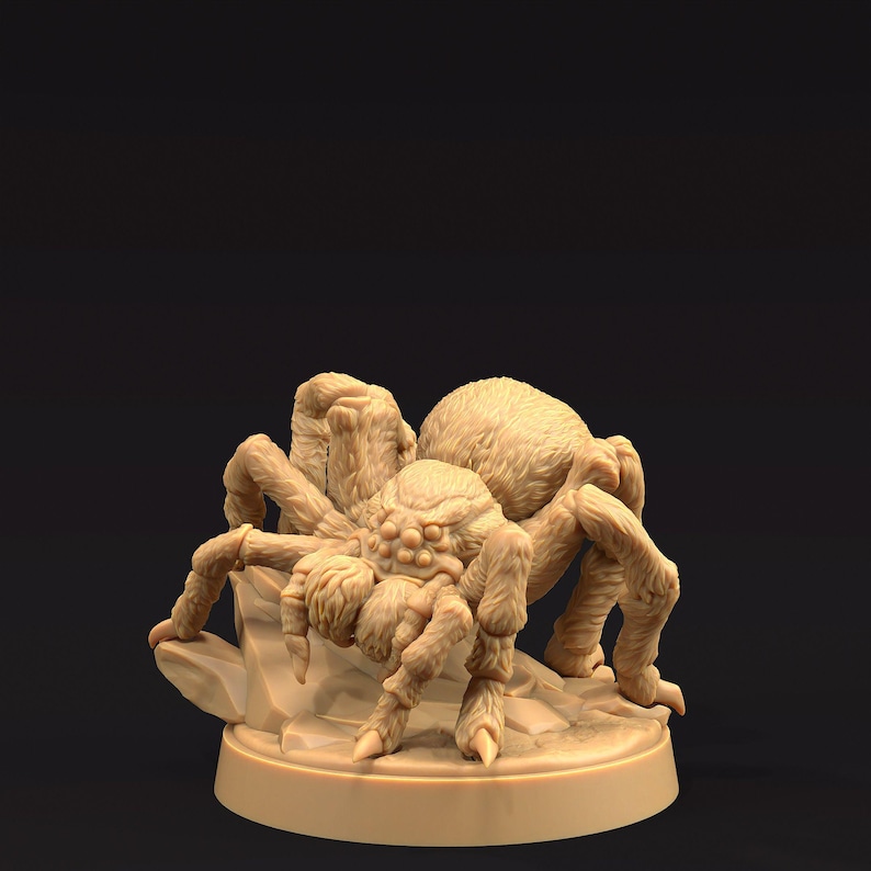 May include: A detailed, beige-colored spider figurine, posed on a rocky base. The arachnid has a hairy body and multiple legs, with a detailed texture. The figurine is set against a dark background, highlighting the intricate design.