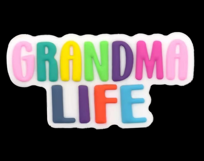 May include: A colorful, whimsical charm with the words "GRANDMA LIFE" in a variety of bright colors. The letters are raised and outlined in white, set against a black background. A fun accessory.