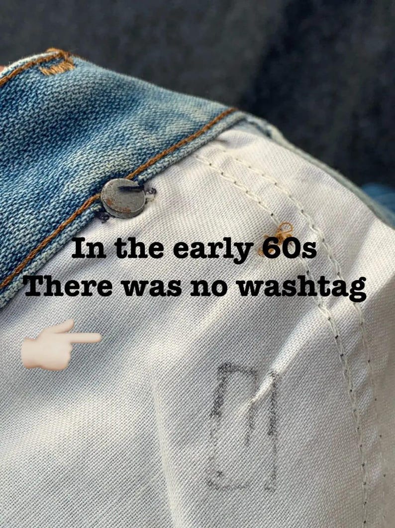 Puede incluir: Primer plano del interior de una chaqueta vaquera. La imagen muestra las costuras, un bot&oacute;n met&aacute;lico y el texto "In the early 60s There was no washtag" con un emoji de mano se&ntilde;alando.