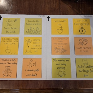 May include: A white paper sheet featuring two columns of square adhesive notes in yellow and orange. Each note contains black line art illustrations and religious text, including phrases like I am chosen by God, God is with me, and I choose faith over doubt.