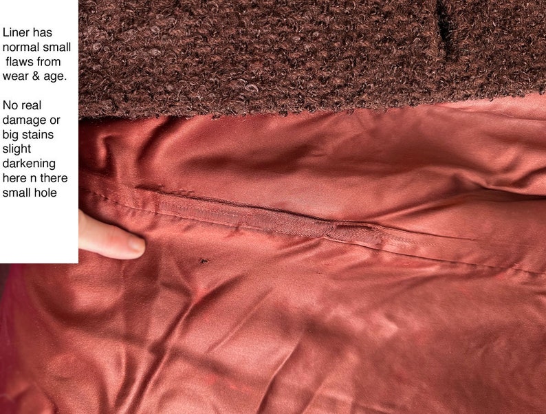 May include: Close-up of the lining of a brown jacket. The lining is a reddish-brown color and has a small hole in it. The text "Liner has normal small flaws from wear & age. No real damage or big stains slight darkening here n there small hole" is visible in the image.