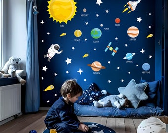 May include: A child sits on a blue rug with a star pattern, playing with a toy truck. The wall behind them is painted blue and decorated with a solar system themed wall decal featuring planets, stars, and an astronaut. The decal includes the names of the planets: Mercury, Venus, Earth, Mars, Jupiter, Saturn, Uranus, and Neptune.