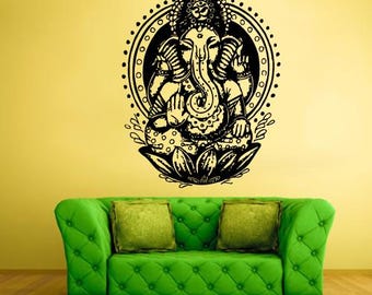 May include: Black and white wall decal of the Hindu deity Ganesha, sitting in a lotus position with his trunk curled up. The decal is surrounded by a circular design with dots and a floral pattern.