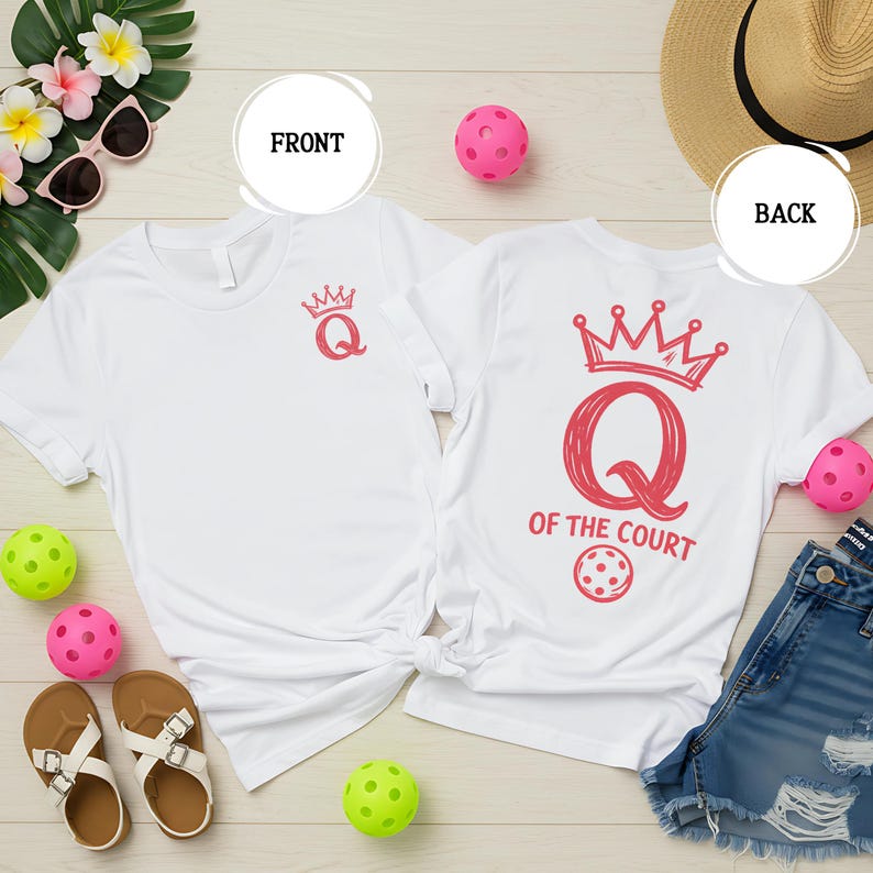 May include: White t-shirts with a red crown and the letter "Q" design. One shirt has "Q" with a crown on the front. The other shirt has "Q OF THE COURT" with a pickleball graphic on the back. Accessories include sunglasses, sandals, and pickleballs.