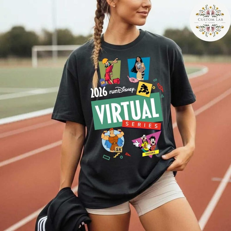 May include: Black t-shirt with a colorful graphic design for the 2016 runDisney Virtual Series. The design includes cartoon characters and the text "VIRTUAL SERIES" in a green rectangle. The shirt is worn by a person on a running track.