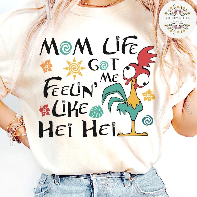 May include: White t-shirt with a colorful graphic of a rooster with the text "Mom Life Got Me Feelin' Like Hei Hei".