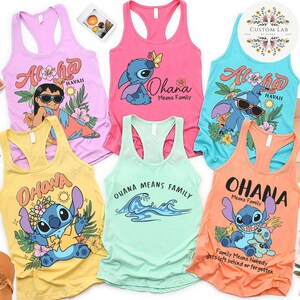May include: Collection of six colorful racerback tank tops featuring cartoon characters and floral designs. The tops are in various colors, including pink, yellow, and blue, with text that reads "Aloha Hawaii" and "Ohana Means Family."