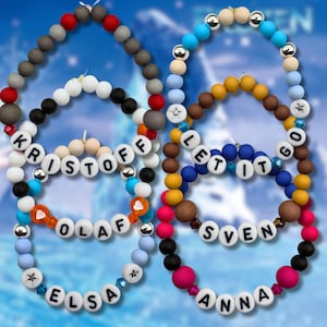 Könnte beinhalten: Bunte Perlenketten mit Namen und Sätzen aus dem Film Frozen. Die Halsketten haben weiße Buchstabenperlen mit Namen wie Elsa, Anna, Olaf, Kristoff und Sven sowie Sätzen wie "Let it Go". Die Perlen sind in verschiedenen Farben gehalten.