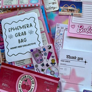 May include: A collection of stationery ephemera including a menu card, a Barbie notepad, a thank you card with a pink star, a sticker sheet with Y2K icons, and a Club Fizz Co cherry soda label. The items feature various fonts, graphics, and colors.