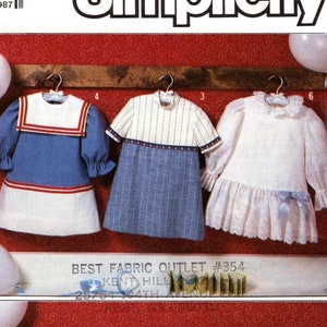 May include: Simplicity pattern 7983 for girls' dresses. The pattern includes five different dress styles: a sailor dress, a striped dress, a white dress with lace trim, a plaid dress with a Peter Pan collar, and a dress with a heart print. The pattern is for size 4.