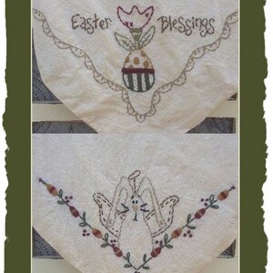May include: Two white fabric squares with embroidered designs. The top square has a flower with an egg and the text "Easter Blessings". The bottom square has a bunny with a vine and leaves.