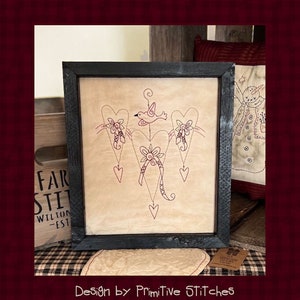 Peut inclure: Une &oelig;uvre d'art encadr&eacute;e avec un motif de c&oelig;urs, un oiseau et des d&eacute;tails floraux. L'&oelig;uvre, dans un cadre noir, a une esth&eacute;tique rustique et vintage. Le texte "Design by Primitive STitcHeS" est en bas.