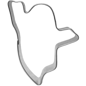 May include: A silver metal cookie cutter shaped like a ghost. The ghost has a rounded head and a long, flowing body.
