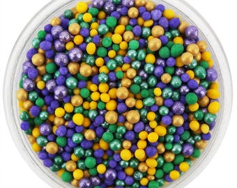May include: A close-up of a bowl filled with colorful sprinkles. The sprinkles are a mix of gold, green, and purple.