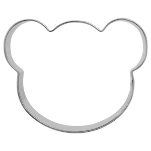 Peut inclure: Un emporte-pièce en métal en forme de tête d'ours. L'emporte-pièce est argenté et a une surface lisse et arrondie.