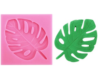 May include: Pink silicone mold with a green monstera leaf design. The mold is used to create edible decorations for cakes and other desserts.