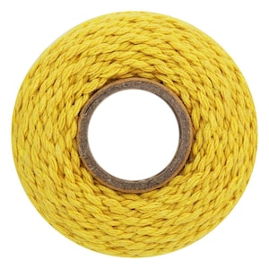 May include: A spool of bright yellow, braided cotton cord. The cord is tightly wound around a cardboard core, creating a circular shape. The yellow color is vibrant and consistent throughout the cord.