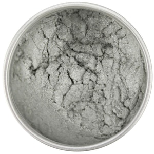 Könnte beinhalten: Nahaufnahme eines Behälters gefüllt mit silbernem Mica-Pulver. Das Pulver hat eine feine, schimmernde Textur.