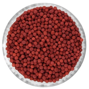 Puede incluir: Un bol de vidrio lleno de pequeñas cuentas redondas de color rojo. Las cuentas son uniformes en tamaño y forma, y están dispuestas en una capa densa y uniforme.