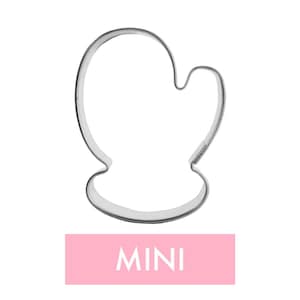 May include: A silver metal mitten-shaped cookie cutter. The word "MINI" is printed in white on a pink rectangular label below the cutter. The cutter has a rounded top and a thumb section, ideal for baking.