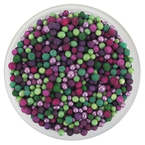 May include: A circular container filled with a mixture of small, spherical sprinkles in various shades of purple, magenta, and green. The sprinkles feature a mix of matte, satin, and metallic finishes, creating a textured, multi-colored appearance.