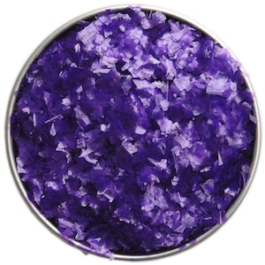 Peut inclure: Vue de dessus d'une boîte métallique ronde remplie de flocons violets translucides. Les flocons, de formes irrégulières et de tailles variées, créent un aspect texturé. Fond blanc.