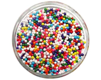 May include: A glass jar filled with colorful sprinkles. The sprinkles are small, round, and come in a variety of colors, including red, orange, yellow, green, blue, and purple.
