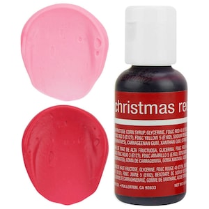 May include: Two small samples of red food coloring, one a light pink and the other a bright red, next to a small bottle of red food coloring labeled "christmas red".