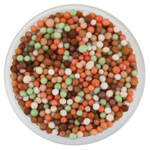 May include: A circular glass bowl filled with a mixture of small, spherical sugar sprinkles in various shades of orange, brown, light green, and white. The sprinkles are densely packed, creating a textured, multi-colored surface within the container.