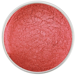 May include: A small round container filled with a fine, red metallic powder. The powder has a slightly textured surface.